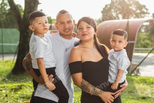 Preview: Portrait of traditional Colombian family of four, young couple with two male children