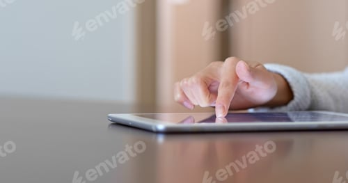 Preview: Woman finger touch on tablet computer at home