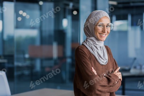 Preview: Portrait of successful and happy businesswoman in hijab, office worker smiling and looking at
