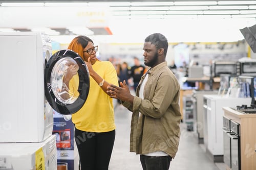 Preview: African American Couple choosing washing machine at electronics store