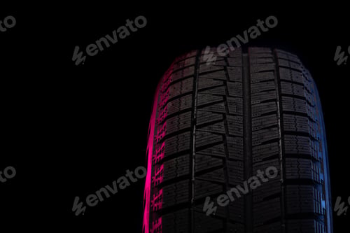 Preview: part of winter tires on a black background close-up with red-blue backlight