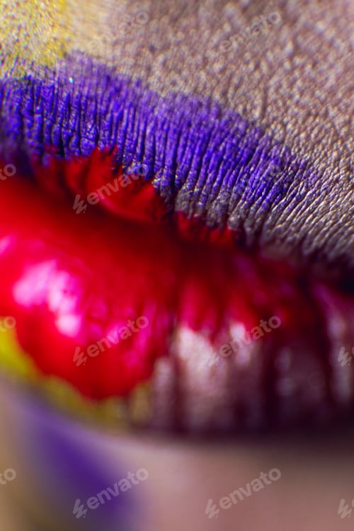 Preview: Close close-up lips with multi-colored paint, yellow, purple.