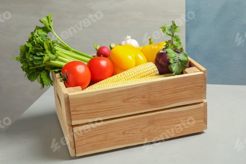 Preview: Wooden crate with fresh vegetables on gray table