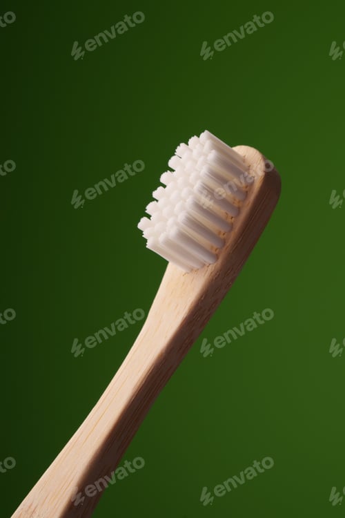 Preview: A wooden toothbrush on a green background. Oral health.