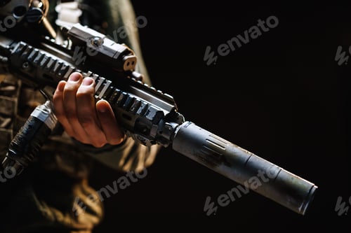 Preview: Unrecognizable special forces soldier standing with rifle against black dark background