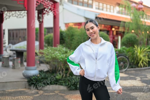 Preview: Young Asian Woman in Sporty Casual Outfit Outdoors in Zen Garden