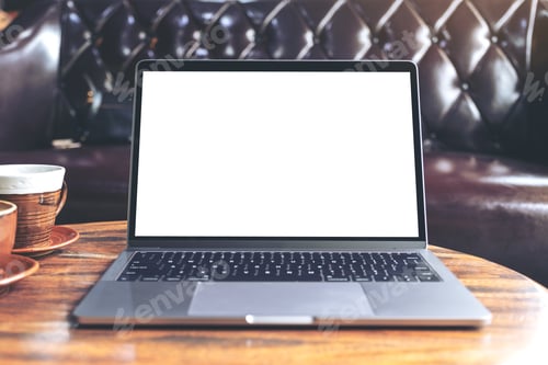 Preview: Mockup image of laptop with blank white desktop screen and coffee cup on wooden table in cafe