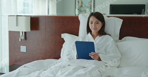 Preview: Woman Relaxing in Bed Using Tablet