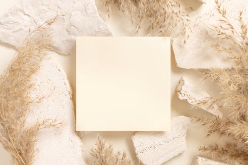 Preview: Blank card near beige travertine stones and dried pampas grass top view, greeting mockup