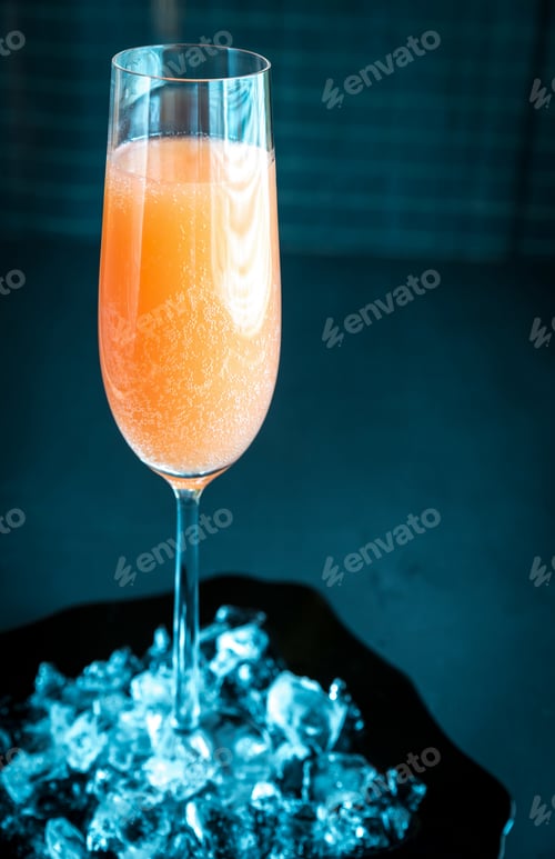 Elegant orange drink in flute glass with ice