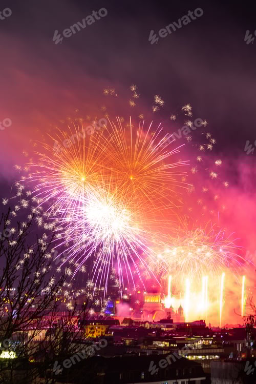 Visualização: Foto vertical dos fogos de artifício coloridos sobre uma cidade no céu noturno