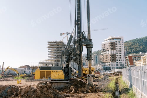 Preview: Crawler drilling machine drills the ground to install piles near a multi-storey building