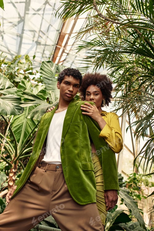 Preview: Young couple sharing a moment of love and joy in a vibrant greenhouse filled with lush greenery