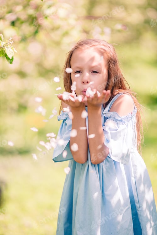Preview: Adorable little girl in blooming apple garden on beautiful spring day