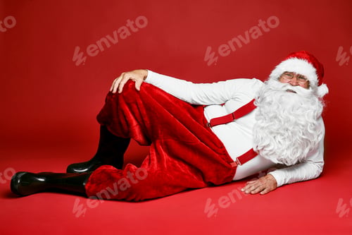 Preview: Portrait of caucasian Santa Claus lying down on the floor
