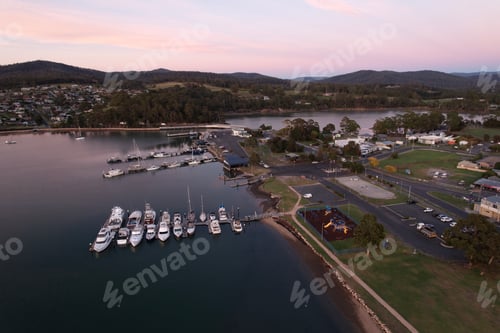 Preview: Aerial sunrise of Saint Helens waterside restaurants and boat-filled pier.