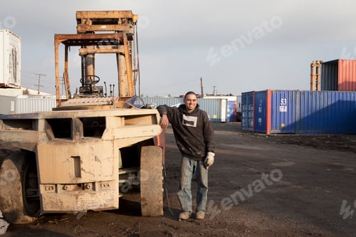 Preview: Man on construction site standing by heavy machinery