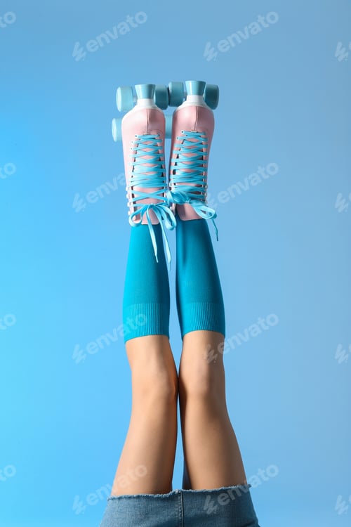 Preview: Woman with vintage roller skates on color background, closeup