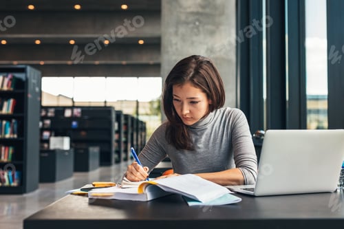 Preview: Female student studying at college library