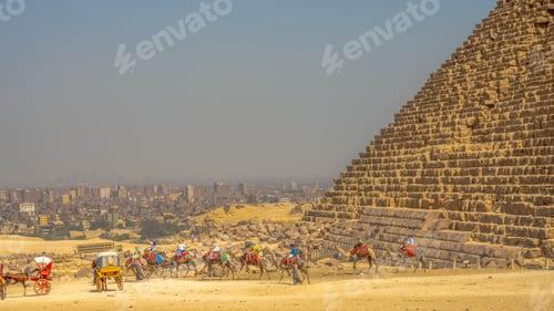 Preview: Group of people riding camels in front of a pyramid