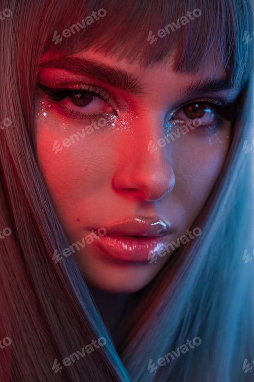 Preview: High fashion model face woman in colorful bright neon UV blue and red lights, posing in studio