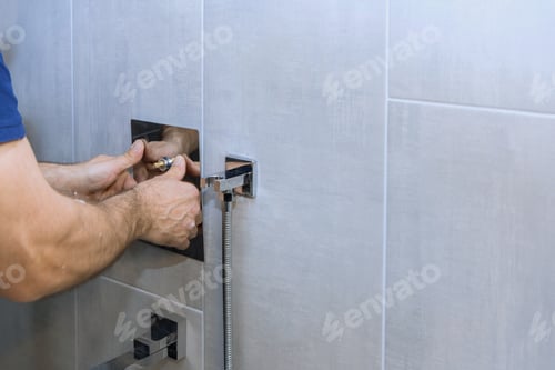 Preview: Person installs modern shower fixture in sleek bathroom during home renovation project