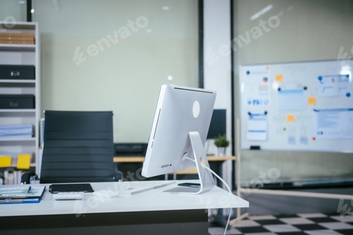 Preview: An empty desk with a computer displaying a graph on the screen, a tablet placed on the table,chai
