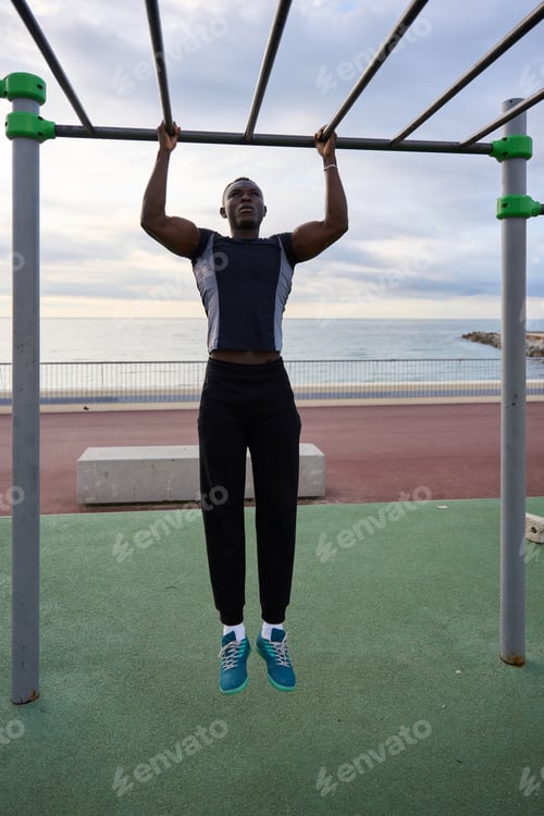Preview: Young black man performing calisthenics by the sea