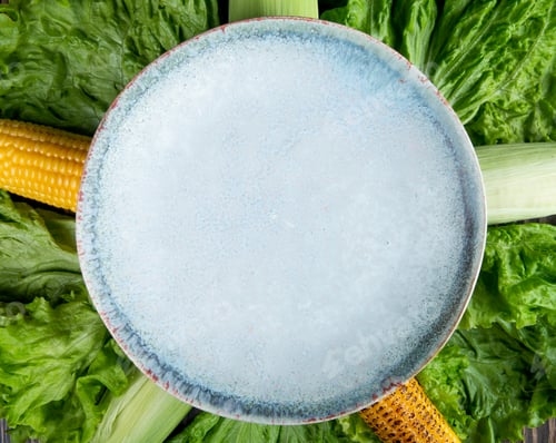Preview: close-up view of empty plate with corns and lettuce for background uses