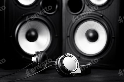 Preview: Photo of black music audio speaker and headphones. Close-up.