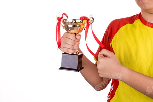 Preview: Proud athlete gestures with firm fist whilst holding gold trophy