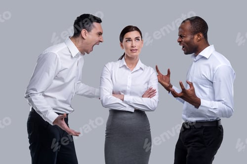 Preview: Teamwork. Pretty Thoughtful Dark-Haired Young Woman Thinking And Standing Between Two Angry Men And