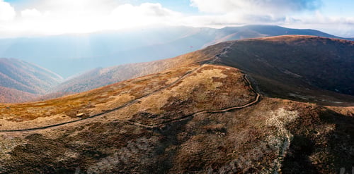 Preview: Long pathways running along mountains under blue sky
