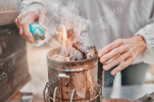 Preview: Fire, camping and hands of a senior person start a flame for heating, preparation of food and cooki