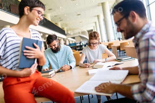 Preview: Happy group of students studying and working together in a college library
