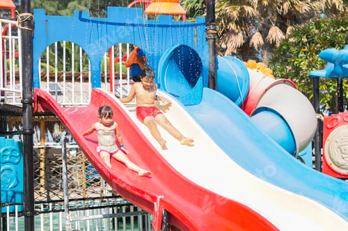 Preview: Asian children siblings swimming and play water slider bar toy in the blue pool. Summer season