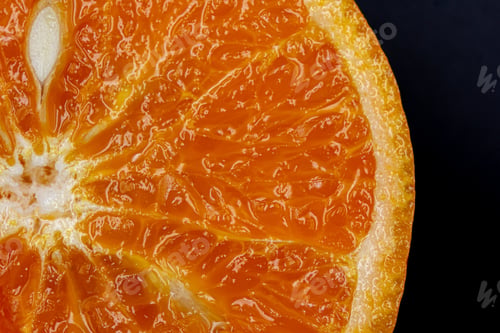 Preview: Oranges on a black background. One orange is cut in half, the other is whole.