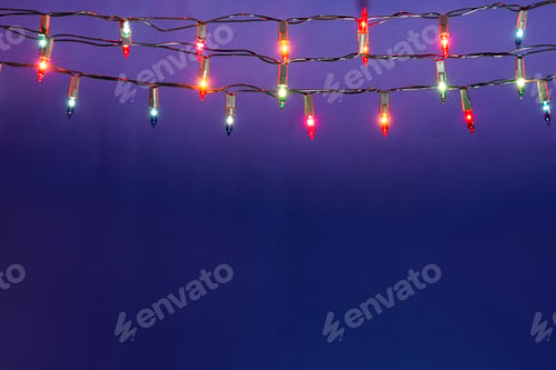 Preview: Christmas lights string on blue background with copy space