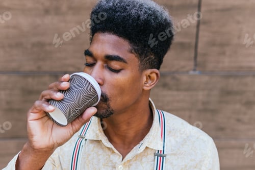 Preview: Serene ethnic man with takeaway coffee