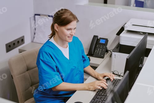 Preview: Caucasian Young Adult Woman Working at Reception Desk in Medical Office