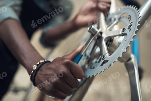 Preview: Shot of an unrecognizable man standing alone in his shop and repairing a bicycle wheel