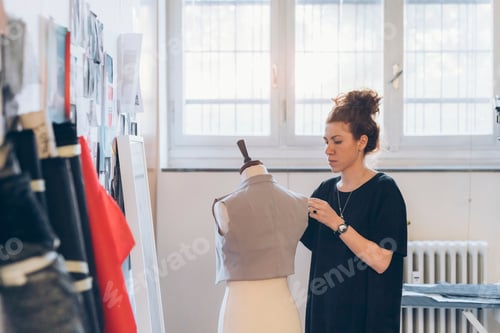 Preview: Fashion designer pinning garment onto dressmaker's dummy