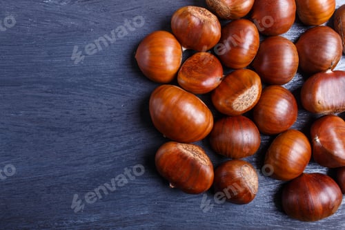 Preview: pile of sweet chestnuts on black wooden background