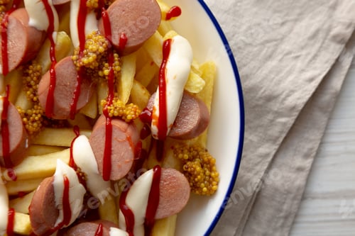 Preview: Homemade Salchipapa Fries with Ketchup, Mustard and Mayo on a Plate, top view. Copy space.