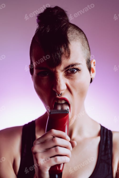 Preview: Young and attractive girl with short hair and punk style looks at camera with impudence.