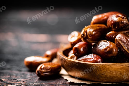 Preview: Delicious dates on a wooden plate.