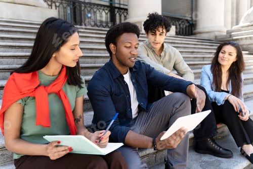 Preview: Group of students are learning together using digital tablet and taking notes