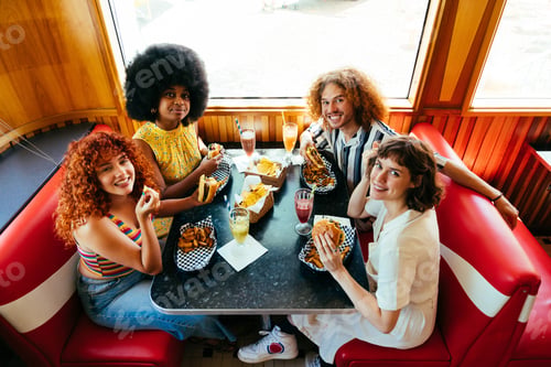 Preview: Multiethnic group of friends having meal at diner restaurant