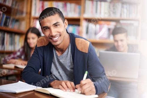 Preview: Cropped portrait of a handsome young student working diligently in his classroom
