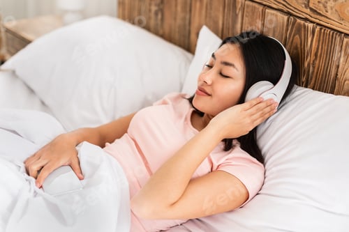 Preview: Korean Woman In Headphones Listening To Music Lying In Bed